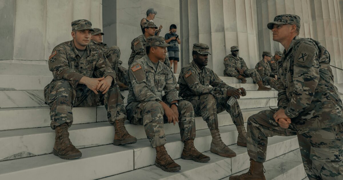 軍人たちが大理石の階段で休憩しながら会話する様子