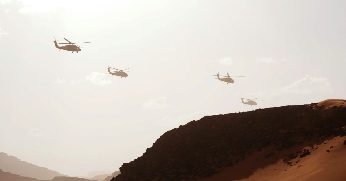 砂漠地帯の上空を編隊飛行する軍用ヘリコプター