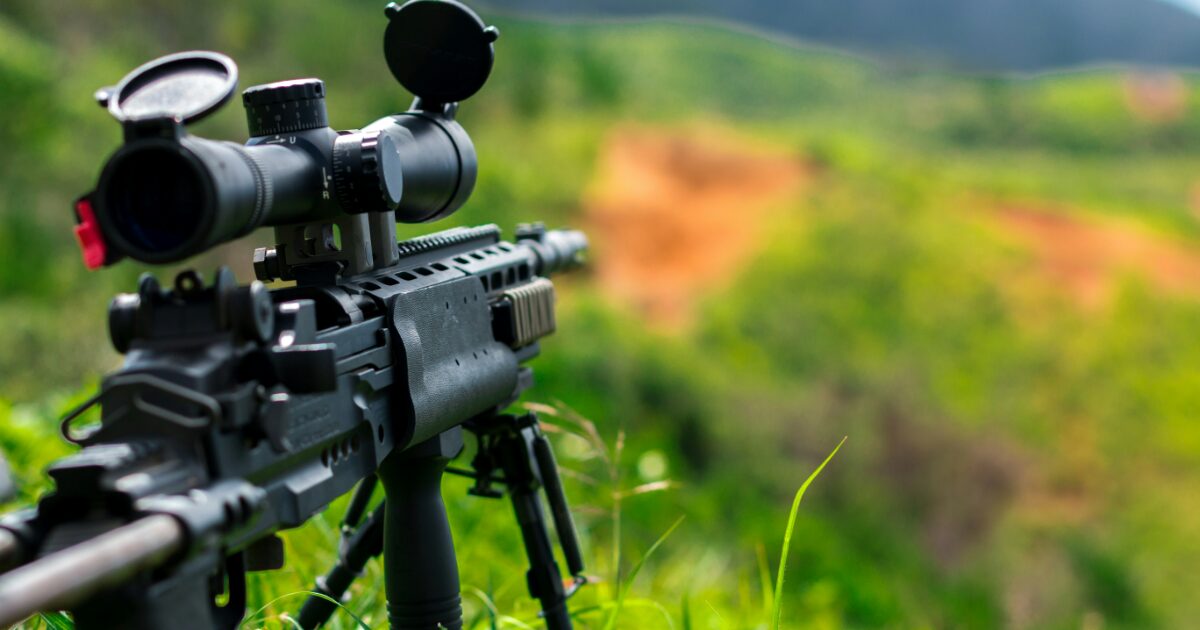 三脚に設置された高倍率スコープ付き狙撃銃のクローズアップ