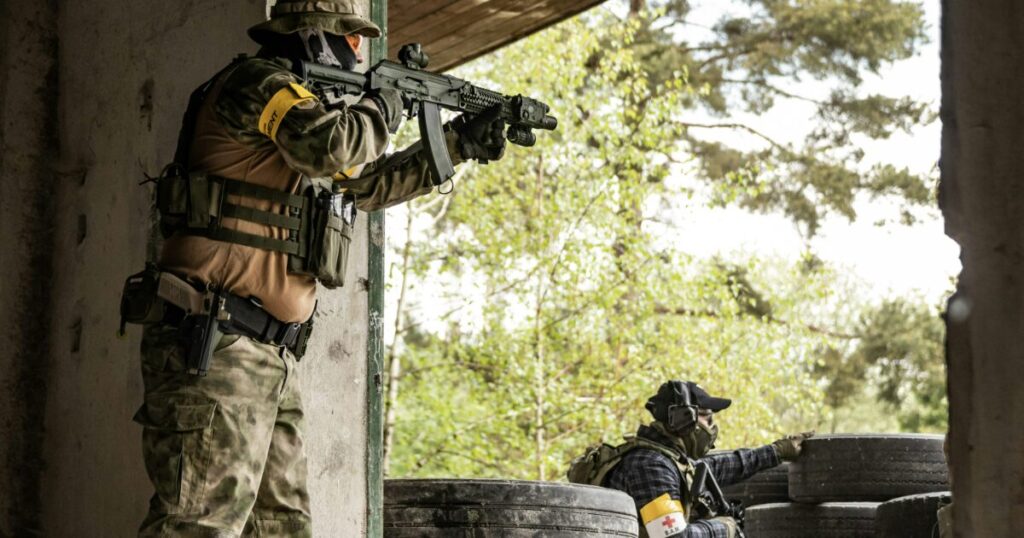 屋内訓練施設で銃を構える兵士たちの戦術訓練