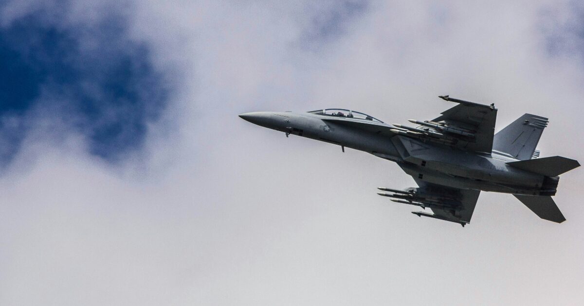 雲間を飛行する武装戦闘機の飛行シーン