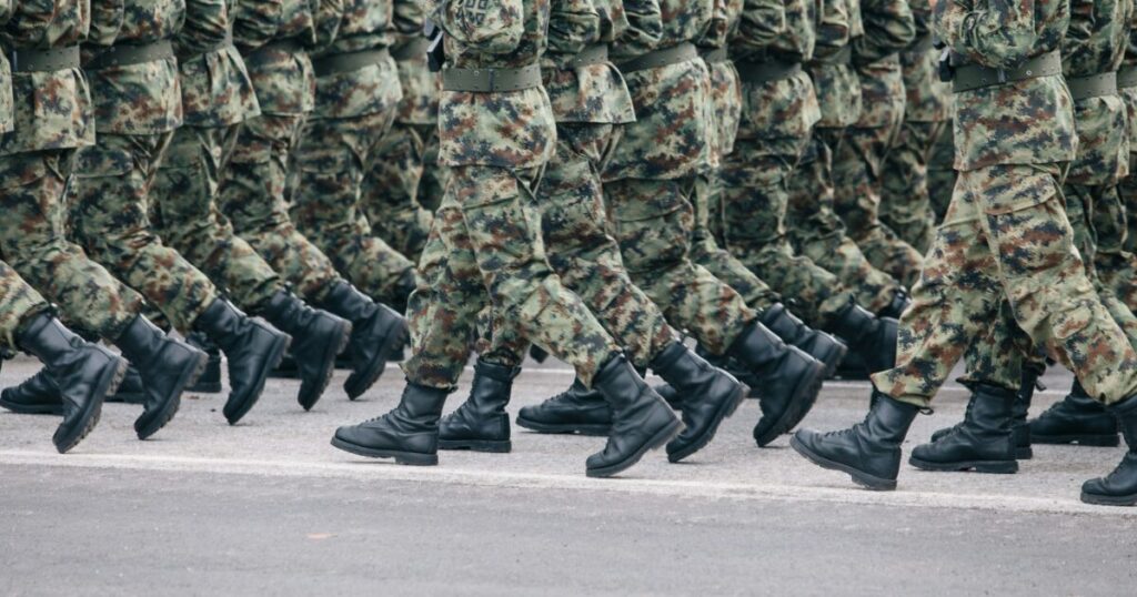 迷彩服の兵士たちが整列して行進する軍事パレード